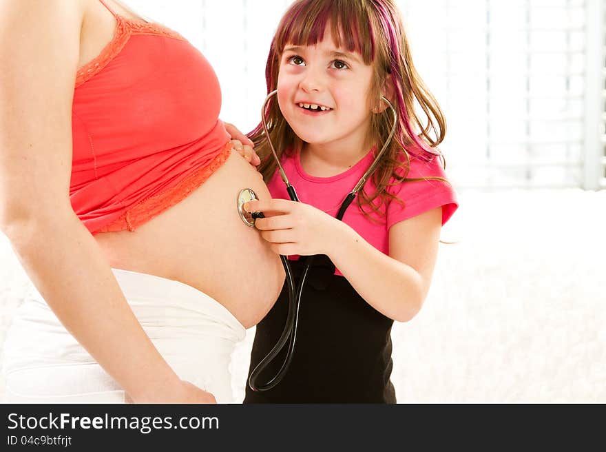 Girl listening to the baby in the mother's abdomen