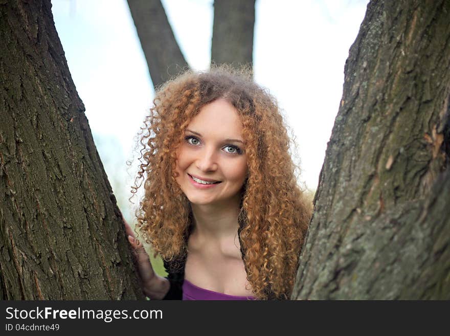 Portrait of a pretty smile girl in the trees