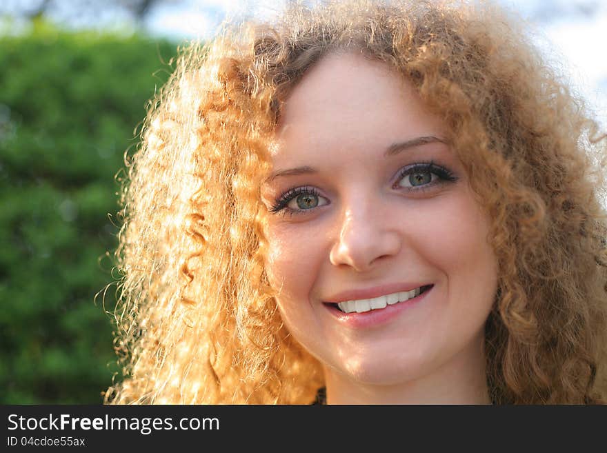 Curly-haired girl smiling in the spring