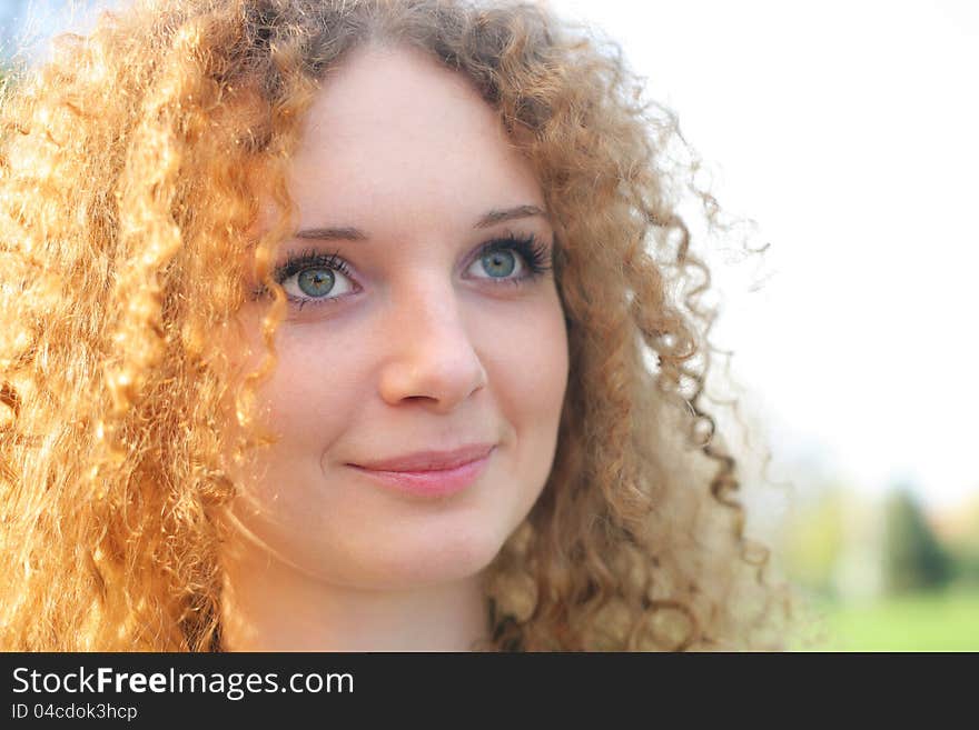 Curly-haired girl in the park in spring