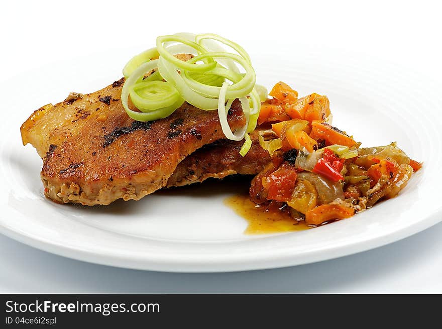 Pork steak with vegetables isolated on white background