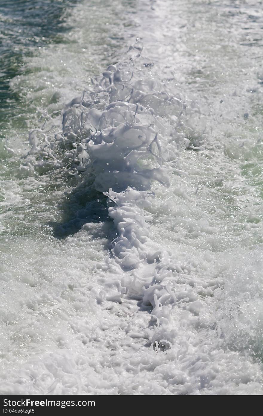 Foam from the wake of a ship out to sea. Foam from the wake of a ship out to sea