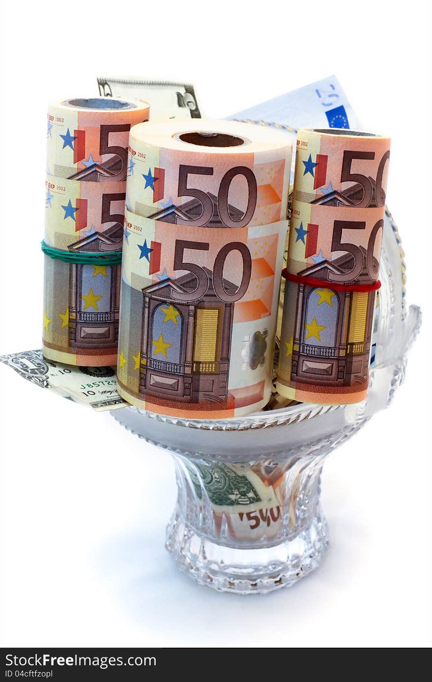 Monetary denominations laid in a vase on a white background