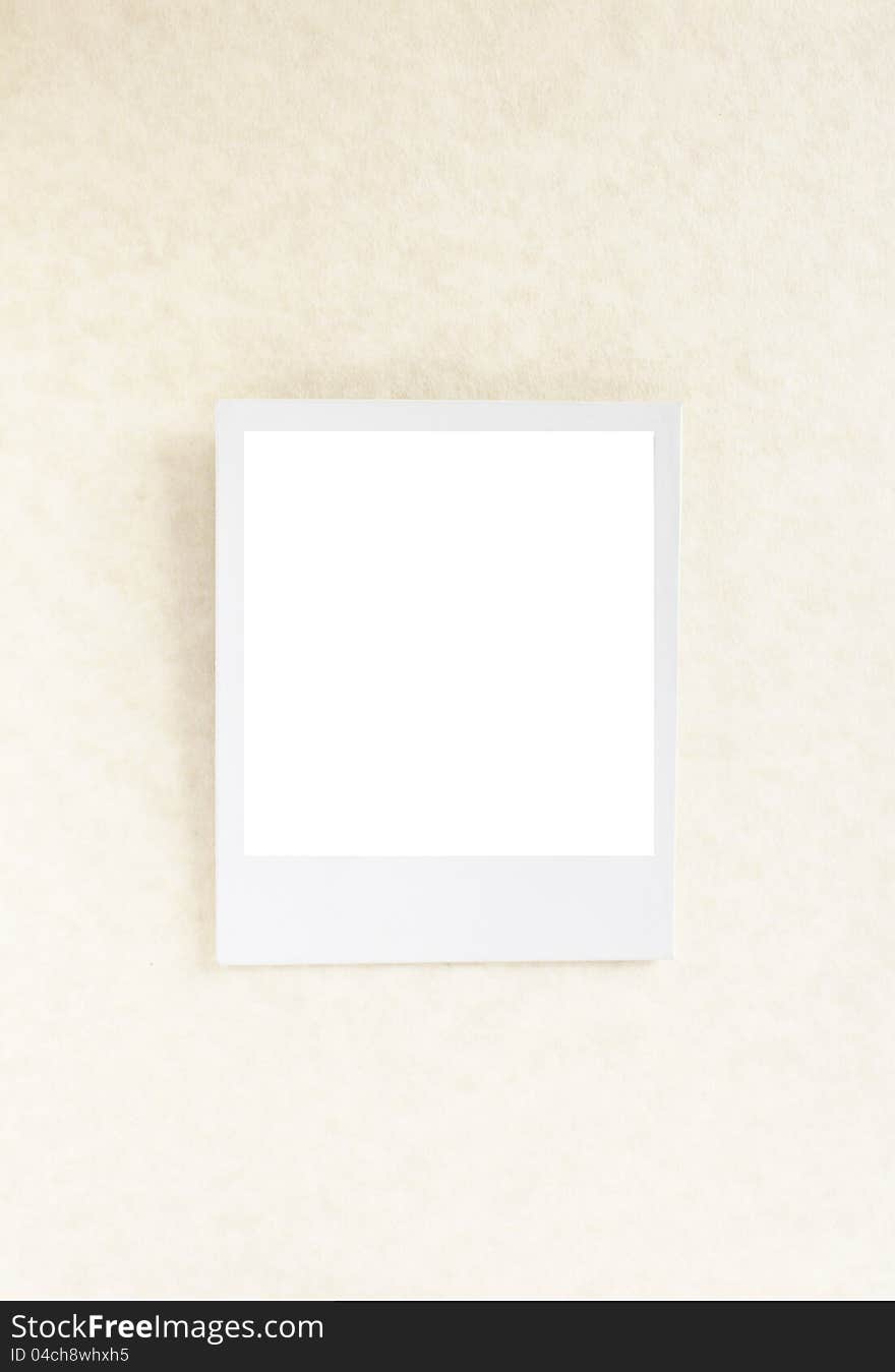 Empty polaroid photograph positioned on parchment paper. Empty polaroid photograph positioned on parchment paper