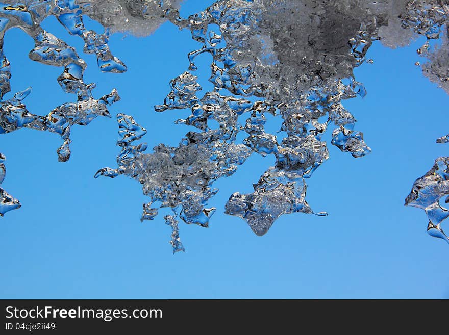 Thawing Icicles against a blue sky. Abstract form. Thawing Icicles against a blue sky. Abstract form.