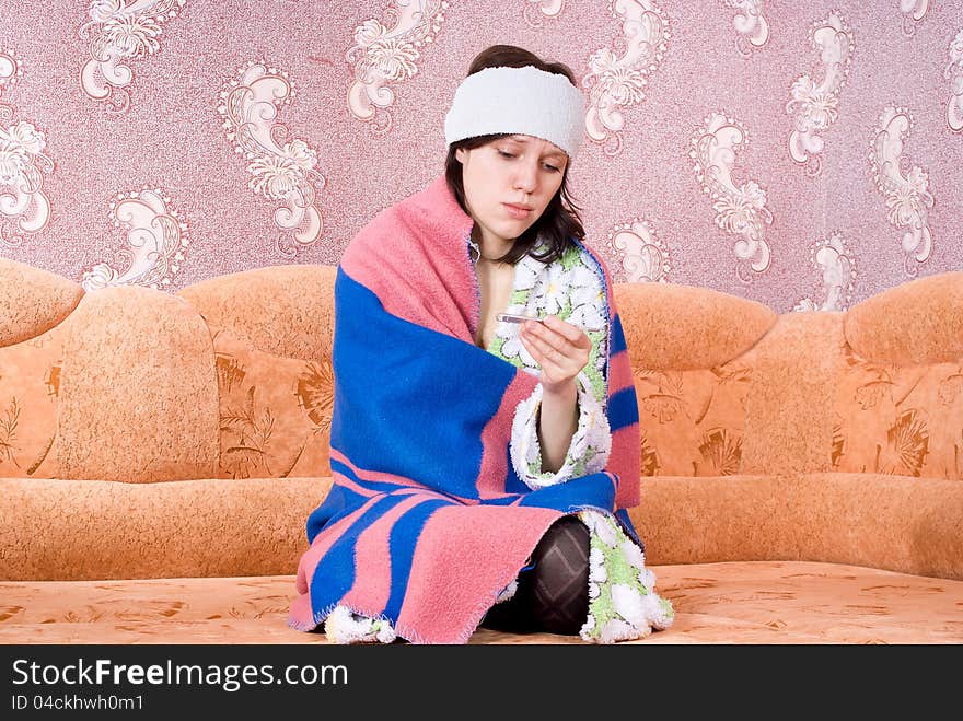 Thermometer girl in a bathrobe on the couch