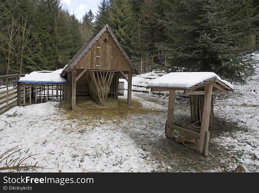 Wooden shelter for wild animals in winter, wooden fence around the enclosure for wild animals. Wooden shelter for wild animals in winter, wooden fence around the enclosure for wild animals