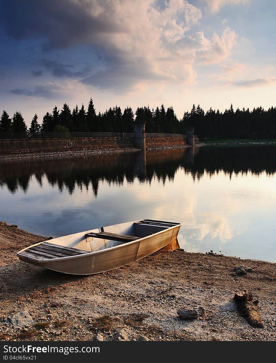 Dam at sunset with boat.