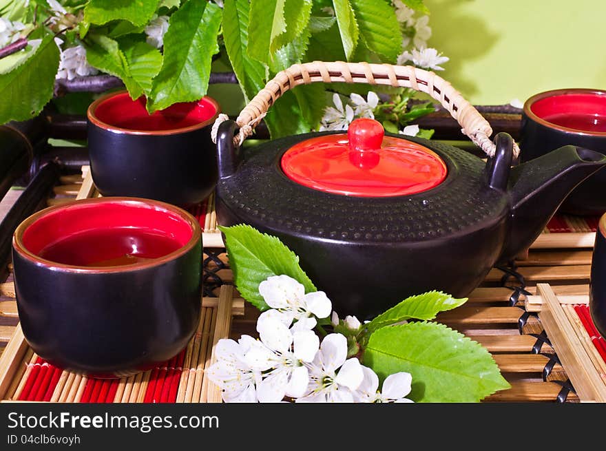 Green tea in a ceramic cup, ceramic teapot, Sakura, chery