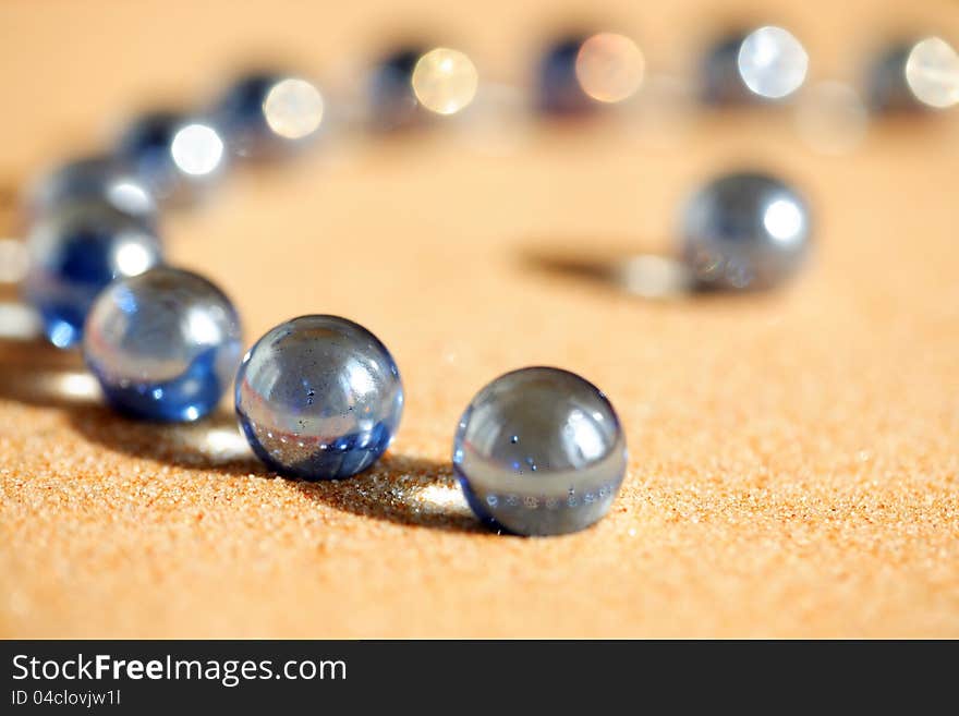 Abstract composition with few blue glass balls on sand surface. Abstract composition with few blue glass balls on sand surface