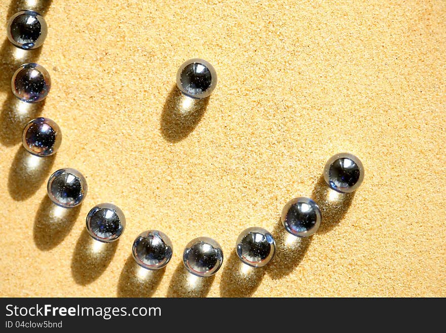 Abstract composition with few blue glass balls on sand surface