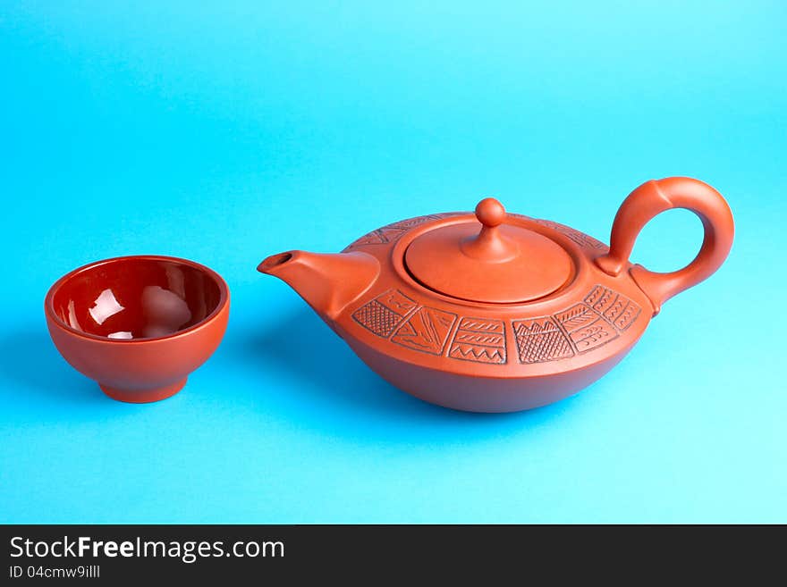 Arabian old ceramic brown teapot with teacups isolated on blue. Arabian old ceramic brown teapot with teacups isolated on blue