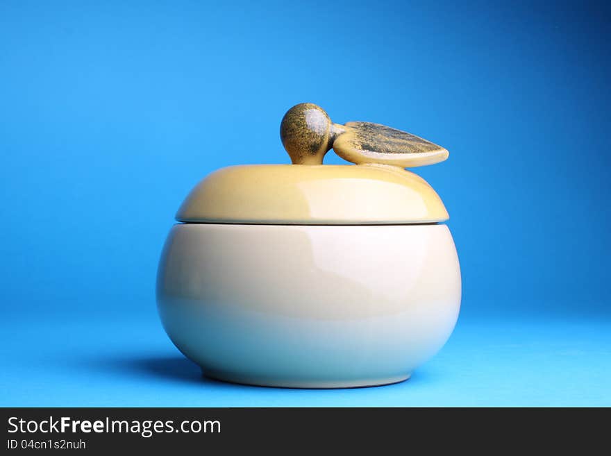 Cup sugar-bowl in the form of an apple isolated on blue background