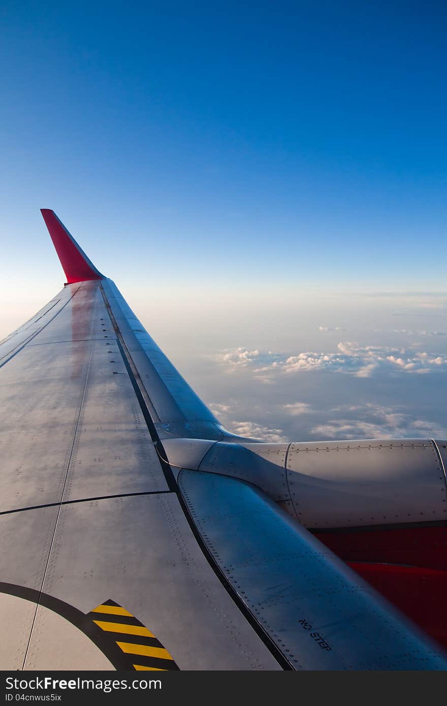 View out of an airplane, over the wing and over the clouds. View out of an airplane, over the wing and over the clouds