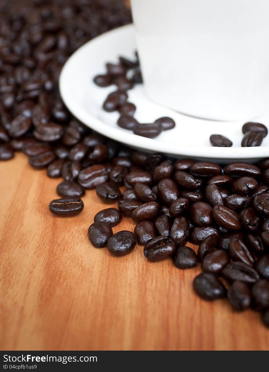 Coffee beans with white coffee cup .