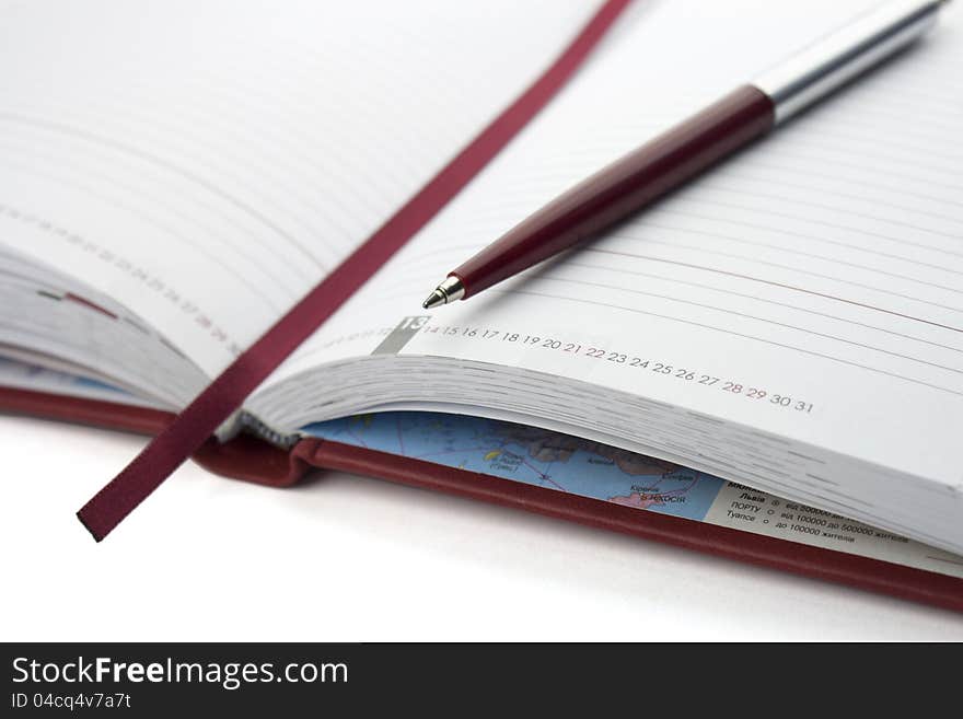 Red open notebook and pen  on white