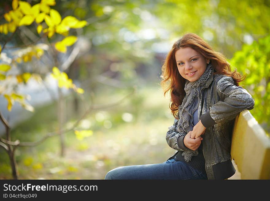 Girl sitting on a bench in autumn. Girl sitting on a bench in autumn