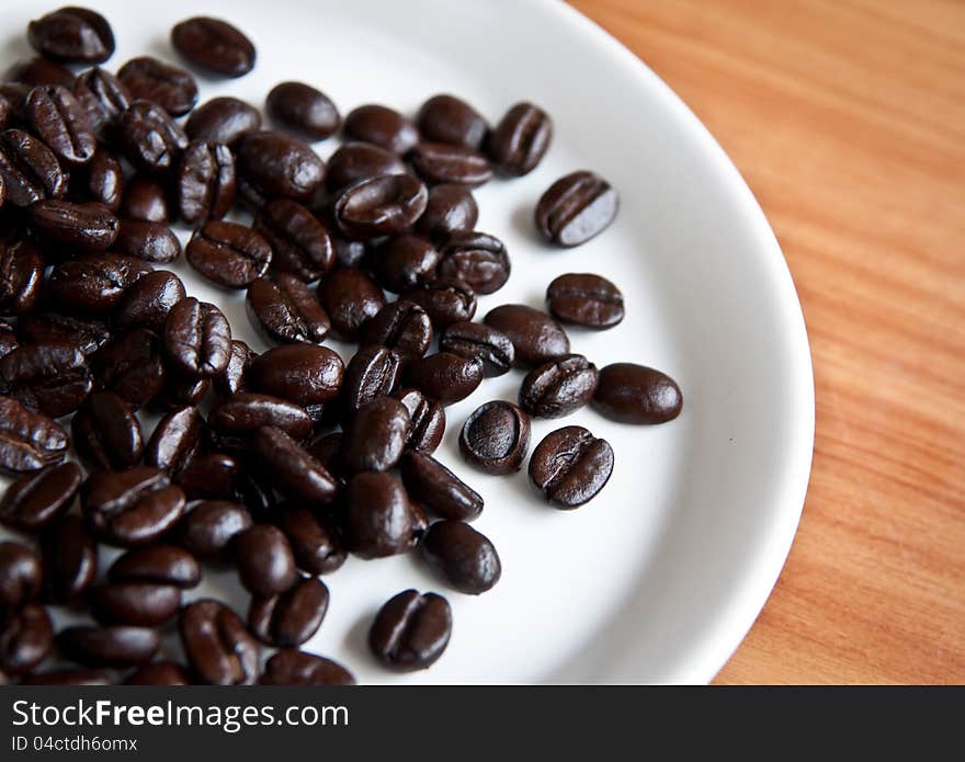 Coffee beans in a disk on  wooden board. Coffee beans in a disk on  wooden board.