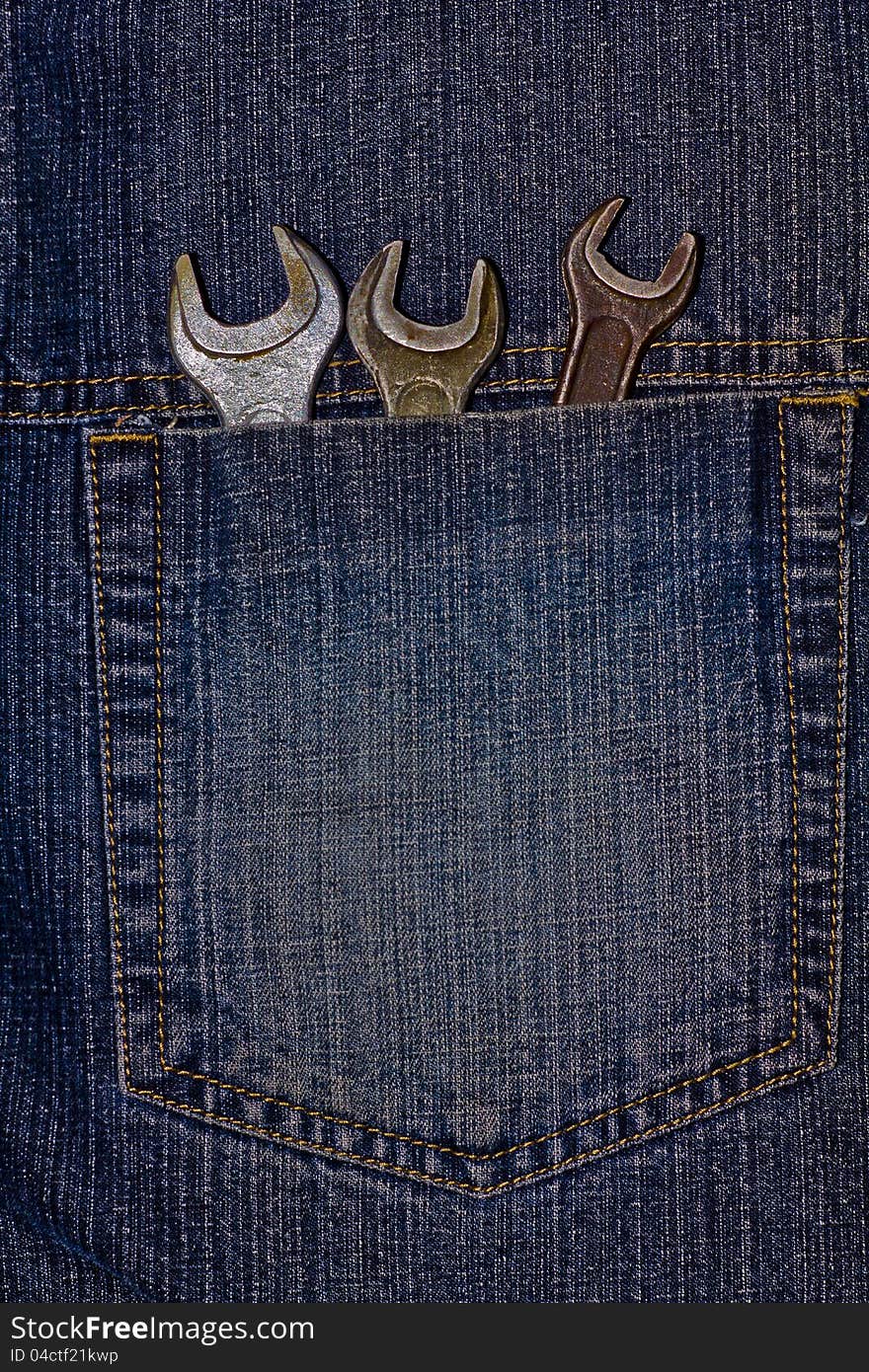 This is three wrenches in pocket of fabric jeans. It is theme of tools.