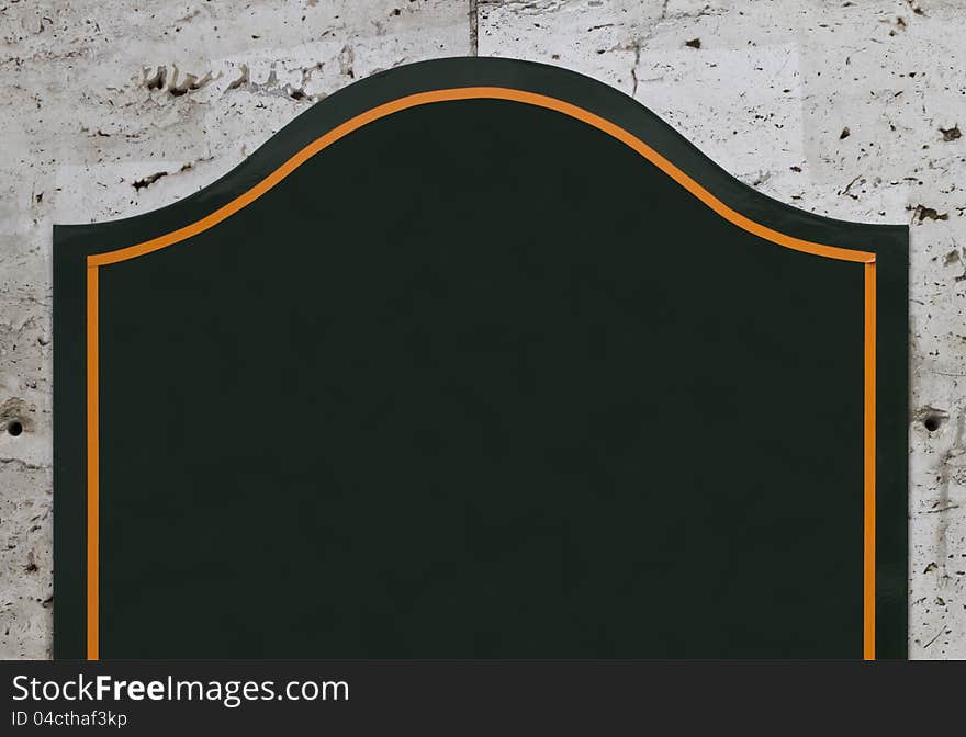 Part of dark green blank sign on concrete wall