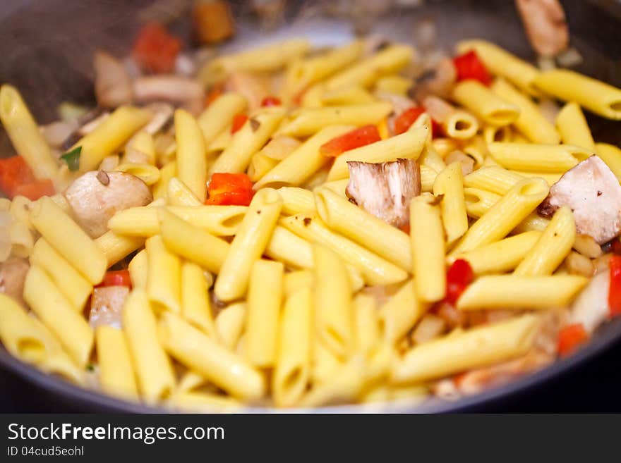 Pasta is being cooked in a pan. Pasta is being cooked in a pan