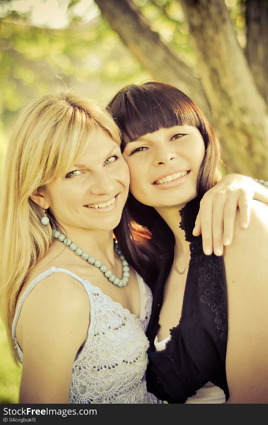 Two beautiful happy sisters in the park. Two beautiful happy sisters in the park