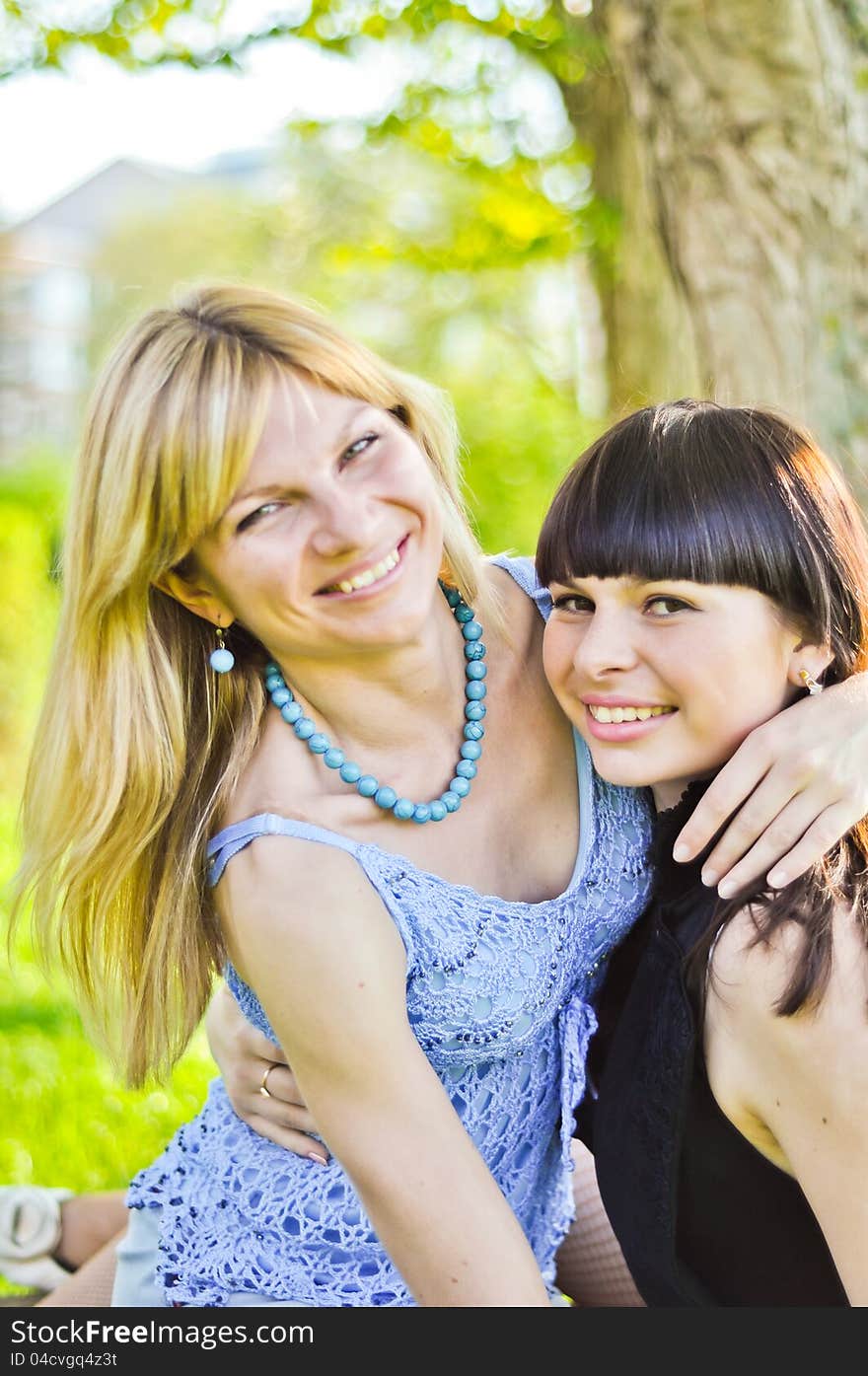 Two beautiful happy sisters in the park. Two beautiful happy sisters in the park