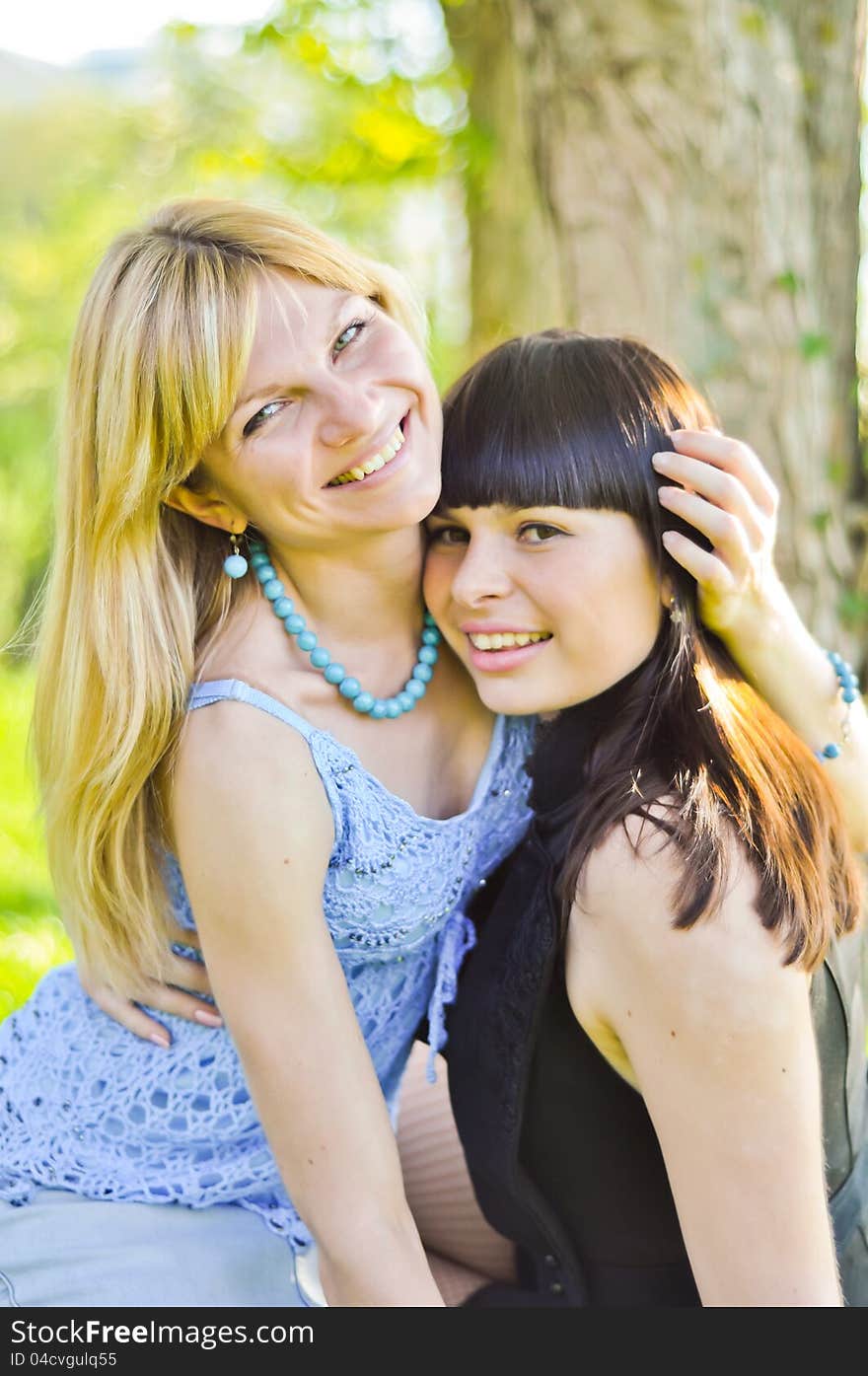 Two beautiful happy sisters in the park. Two beautiful happy sisters in the park