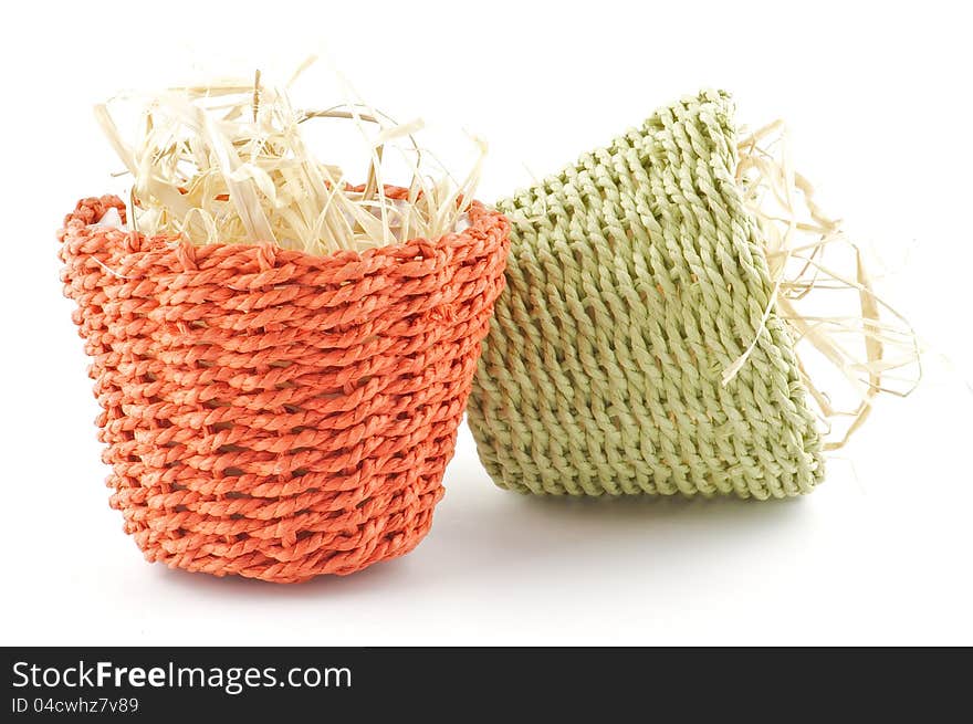 Green and red little wicker flower pots with straw isolated on white background. Green and red little wicker flower pots with straw isolated on white background