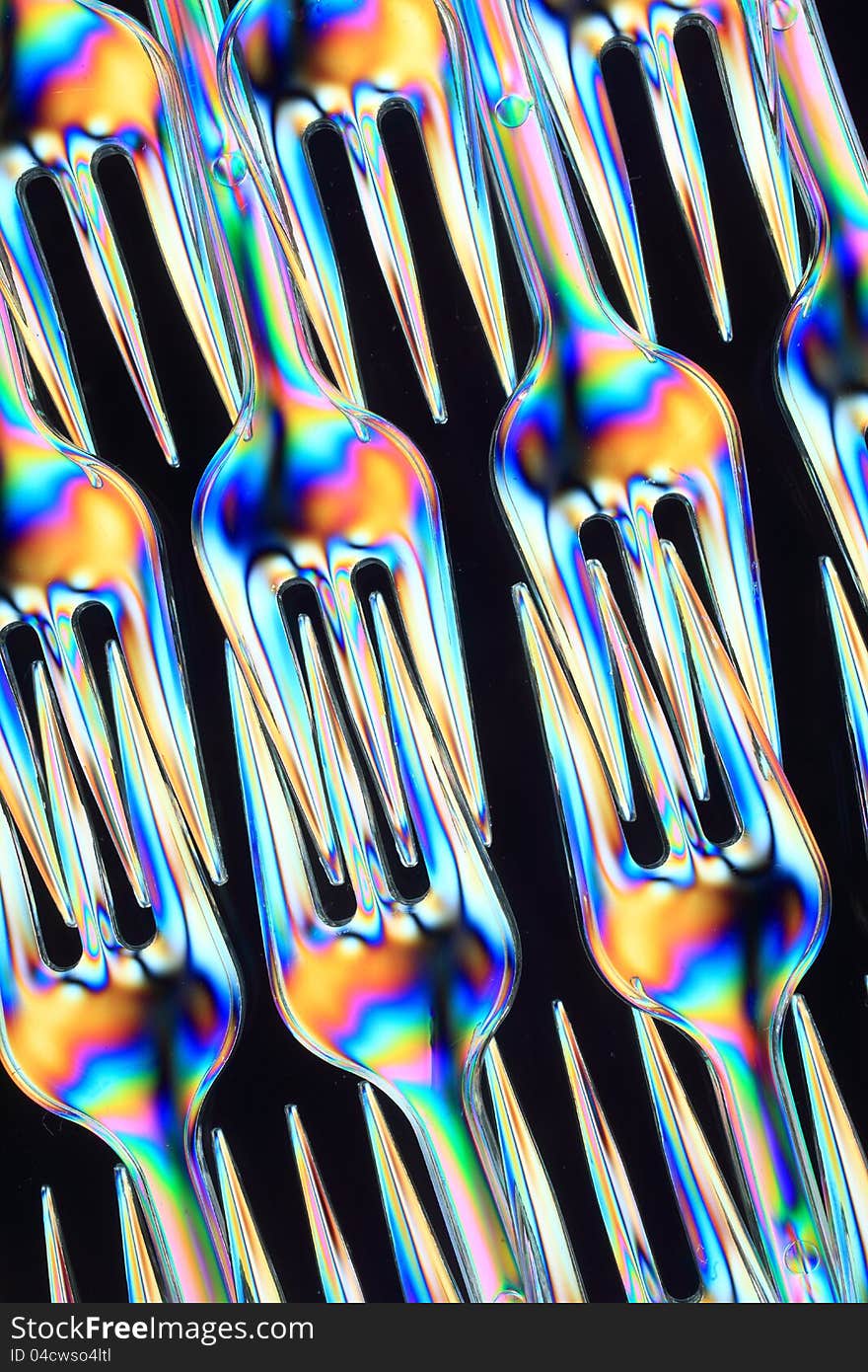 Small eating forks consisting of transparent plastic seen in polarized light. Small eating forks consisting of transparent plastic seen in polarized light