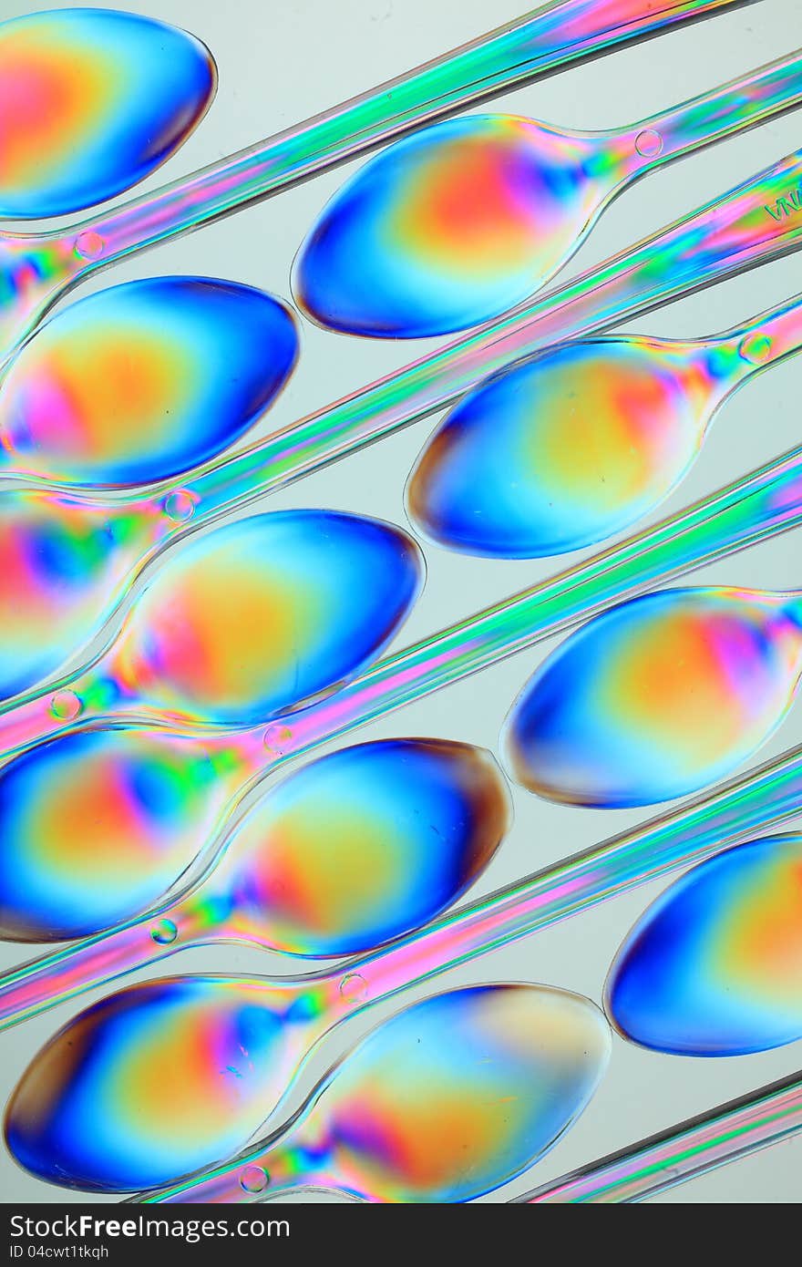 Small spoons consisting of transparent plastic seen in polarized light. Small spoons consisting of transparent plastic seen in polarized light