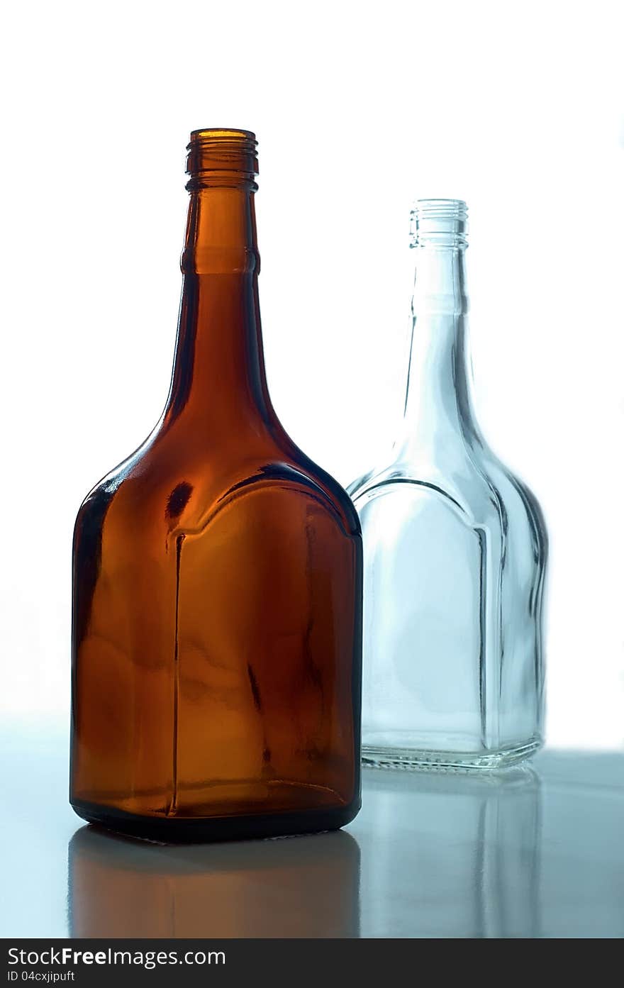 Two empty bottles standing on a white background