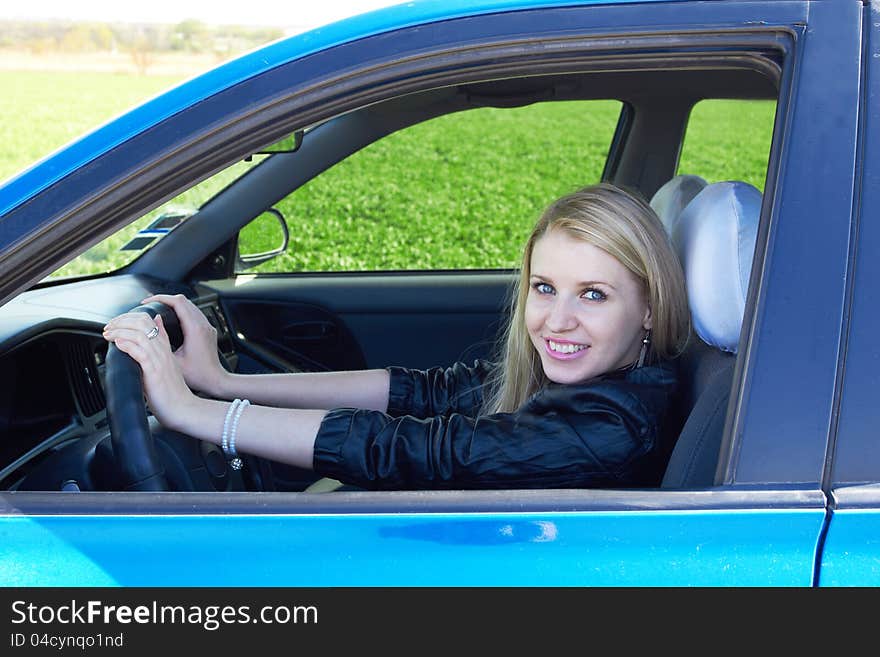 Happy girl in the dark blue car. Happy girl in the dark blue car