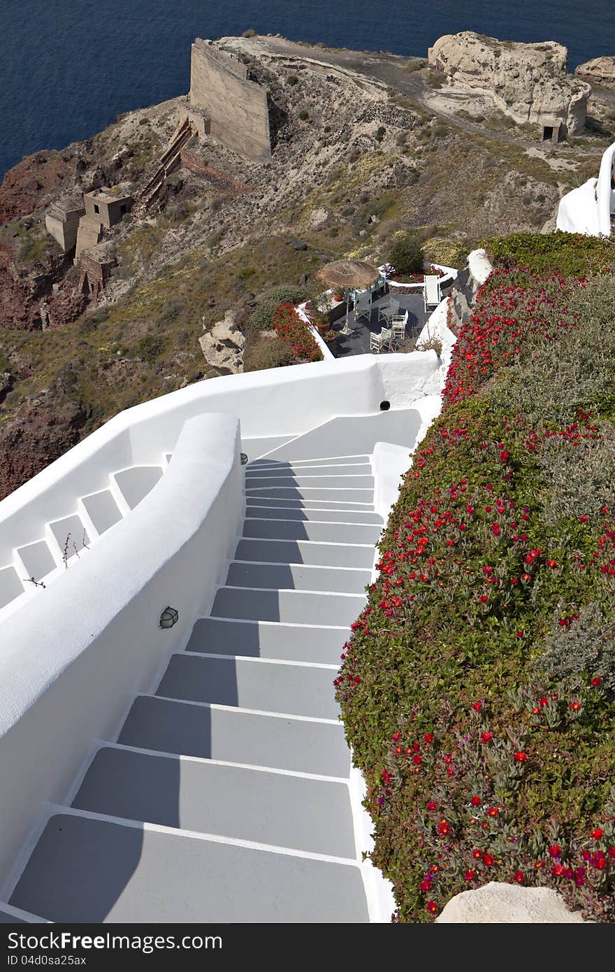 Alley with steps going downwards on the volcanic caldera at Santorini island in Greece