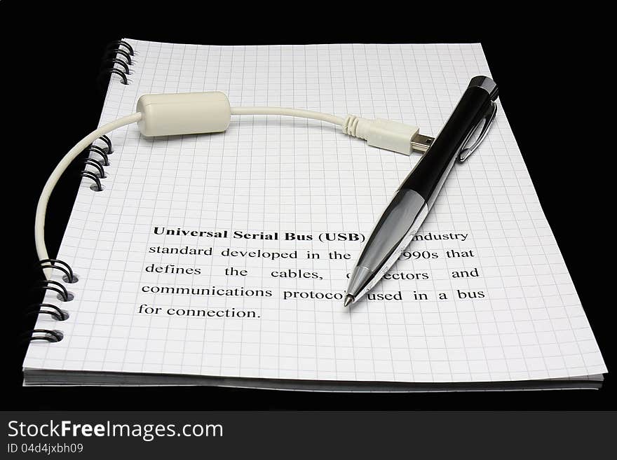 Pen and USB cable on black background