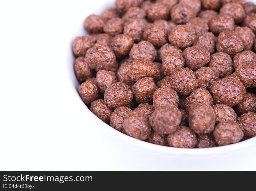 Dry breakfast. Chocolate marbles on a white background. Dry breakfast. Chocolate marbles on a white background