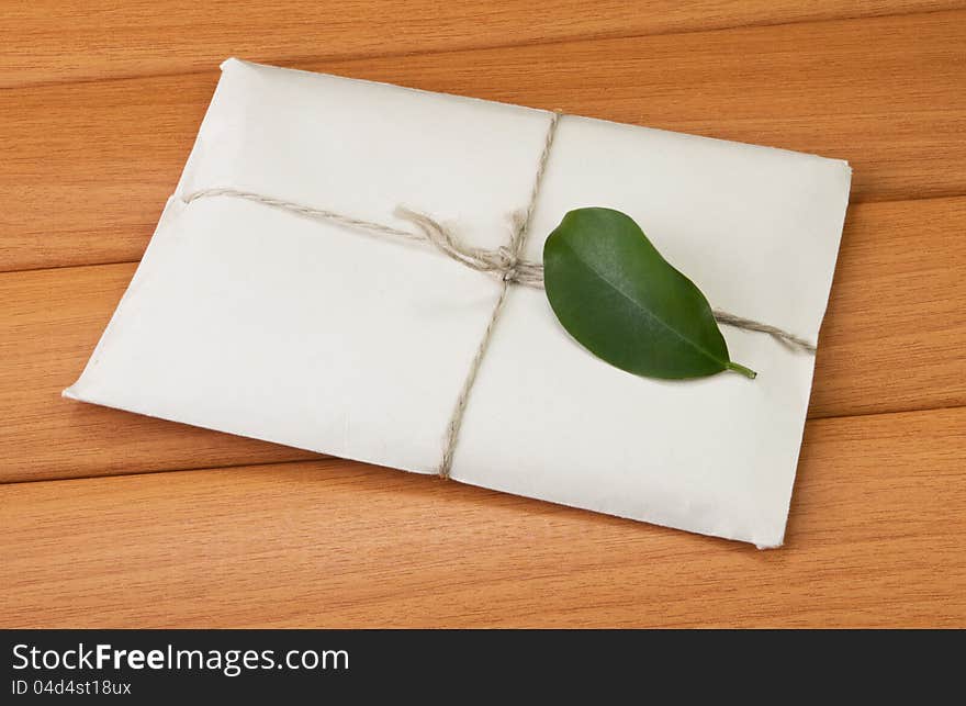 Paper letter with a green leaf on the tree against the background. Paper letter with a green leaf on the tree against the background