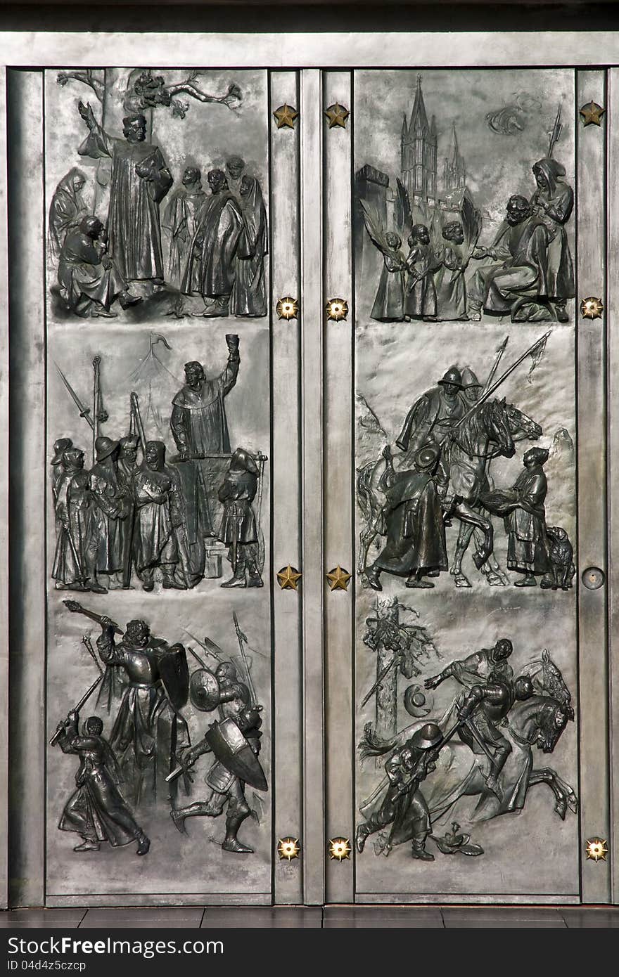 Detail of the door's tomb, metal doors with historical themes, metal statues of soldiers on the door, prague's architectural heritage, illuminated metal doors with war themes. Detail of the door's tomb, metal doors with historical themes, metal statues of soldiers on the door, prague's architectural heritage, illuminated metal doors with war themes