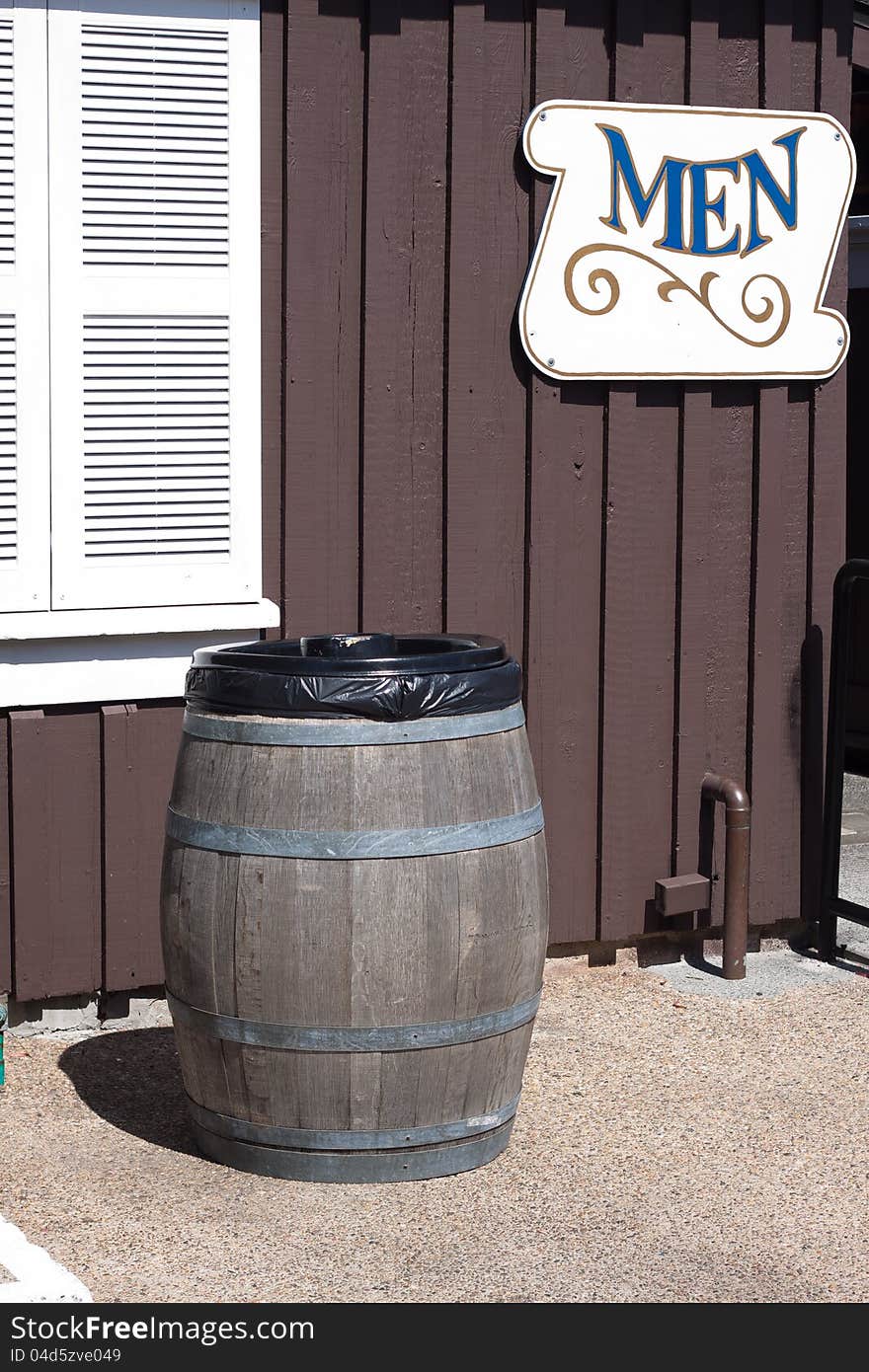 Trash can made from wine bucket stand infront of restroom