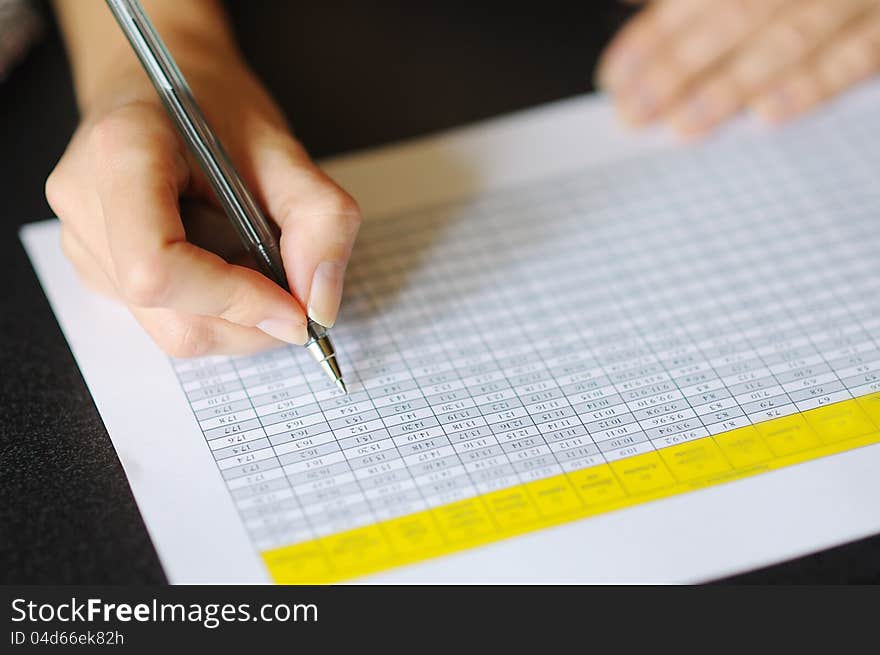 Businesswoman looking table with pen in hand