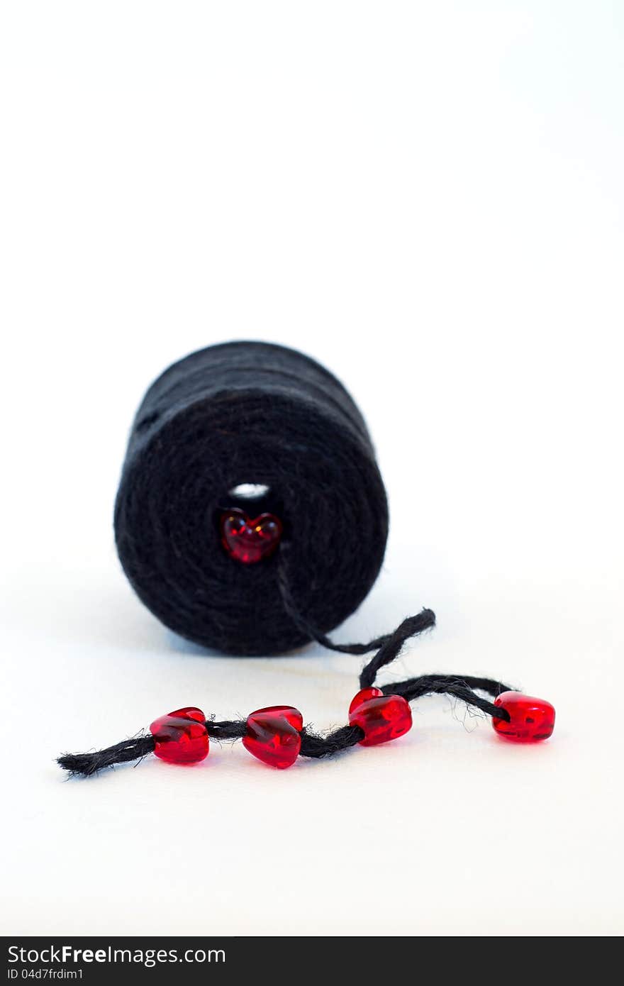 Black spool and red glass hearts an white background. Black spool and red glass hearts an white background