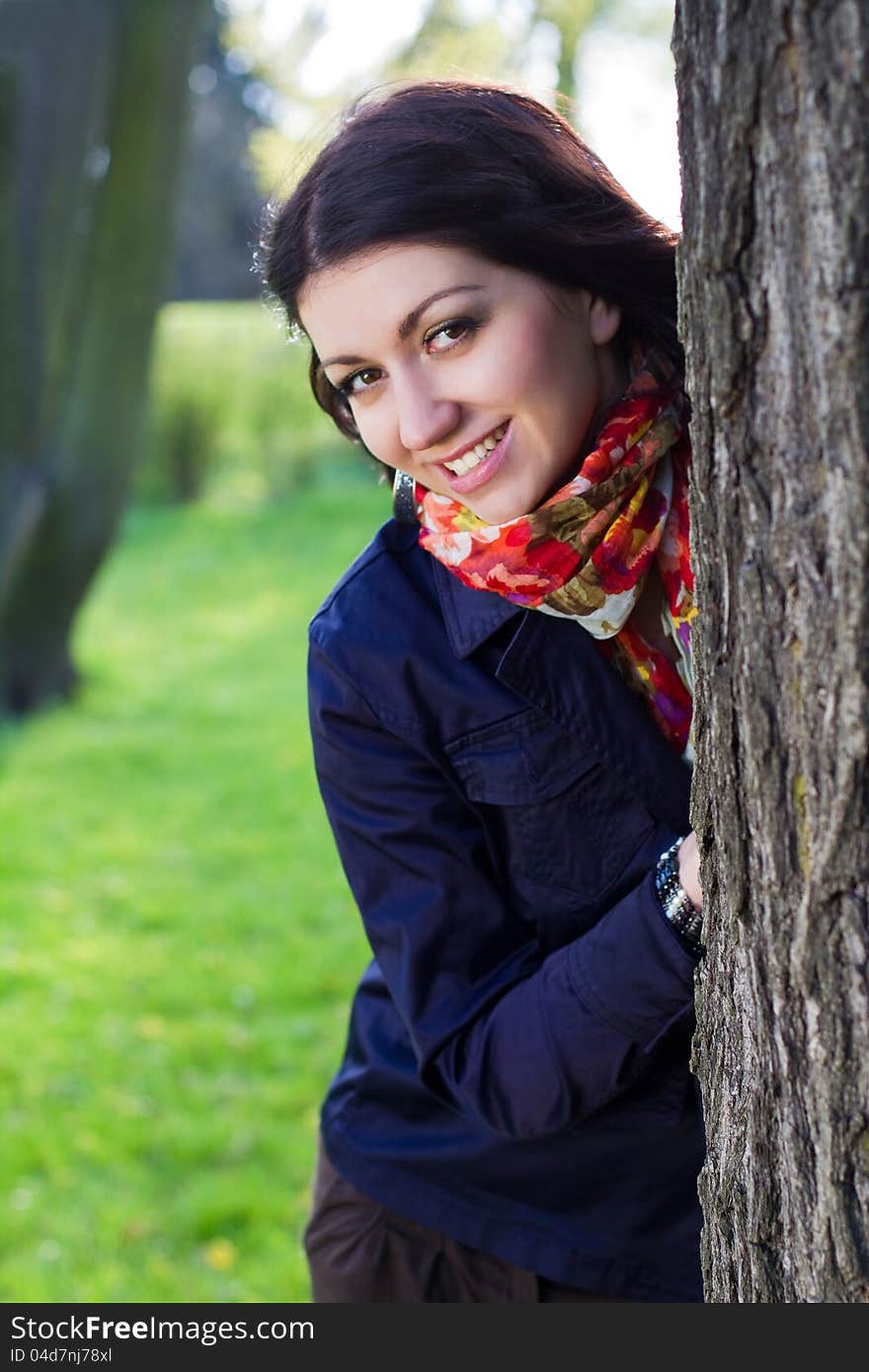 Beautiful young girl near tree