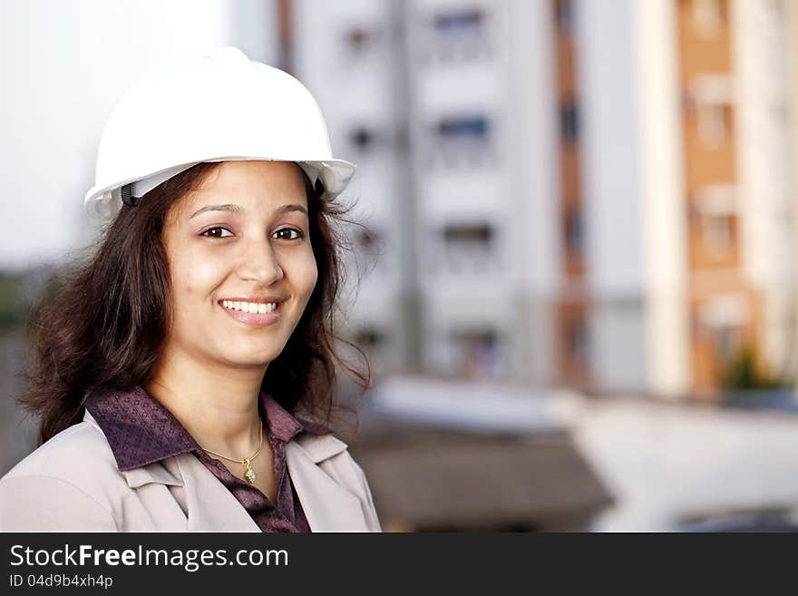 Cheerful young female architect at work place