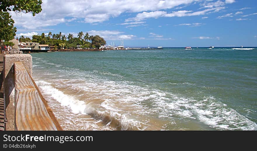 Breaking waves in the foreground, Lahaina Harbor in the background along the popular Front Street on Maui, Hawaii. Breaking waves in the foreground, Lahaina Harbor in the background along the popular Front Street on Maui, Hawaii