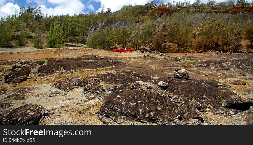 A red Corvette ride in a beautiful rocky mountainous area along the coastline of Maui, Hawaii. A red Corvette ride in a beautiful rocky mountainous area along the coastline of Maui, Hawaii