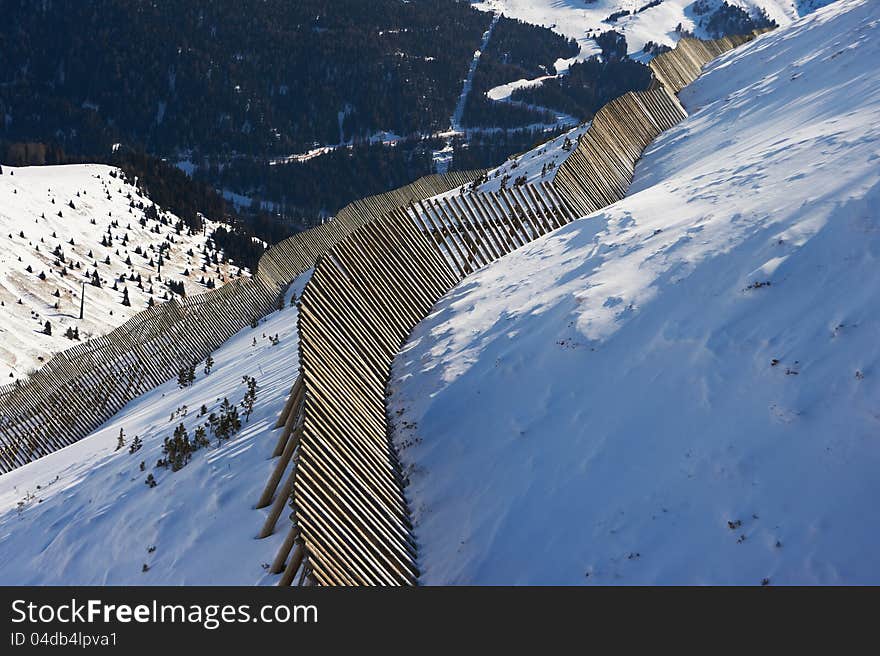 View of the valley from the mountainside with an avalanche fence