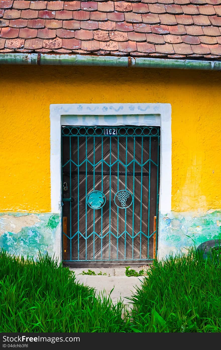 Locked door and colorful yellow wall and grass foreground