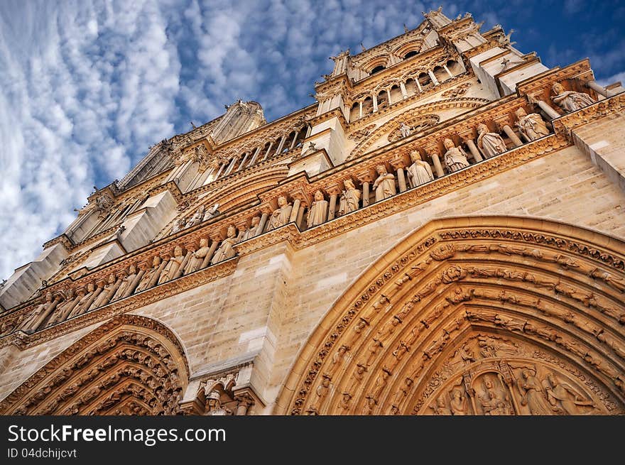 Notre Dame cathedral in Paris, daylight view with blue sky and white clouds