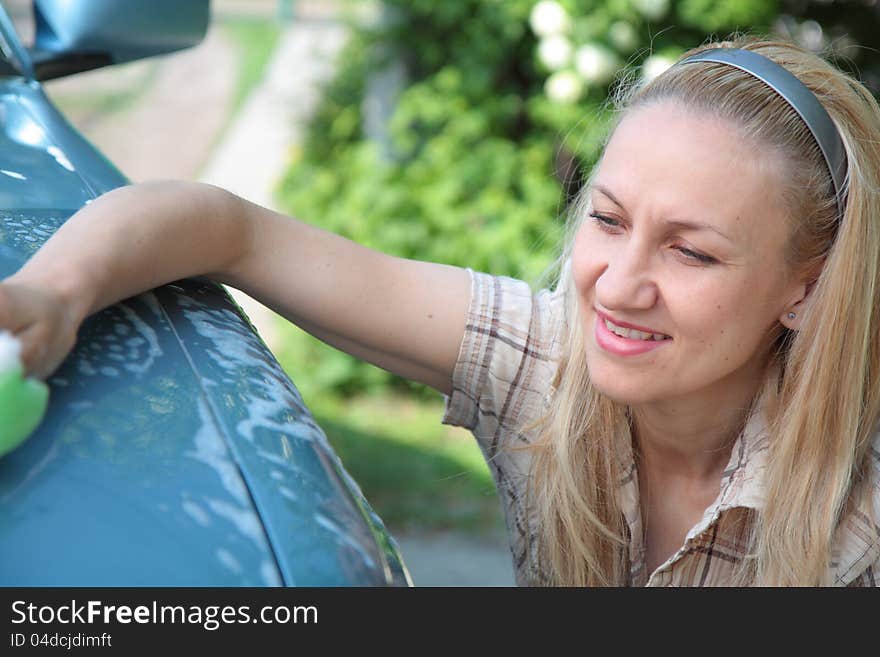 Young woman washing her car