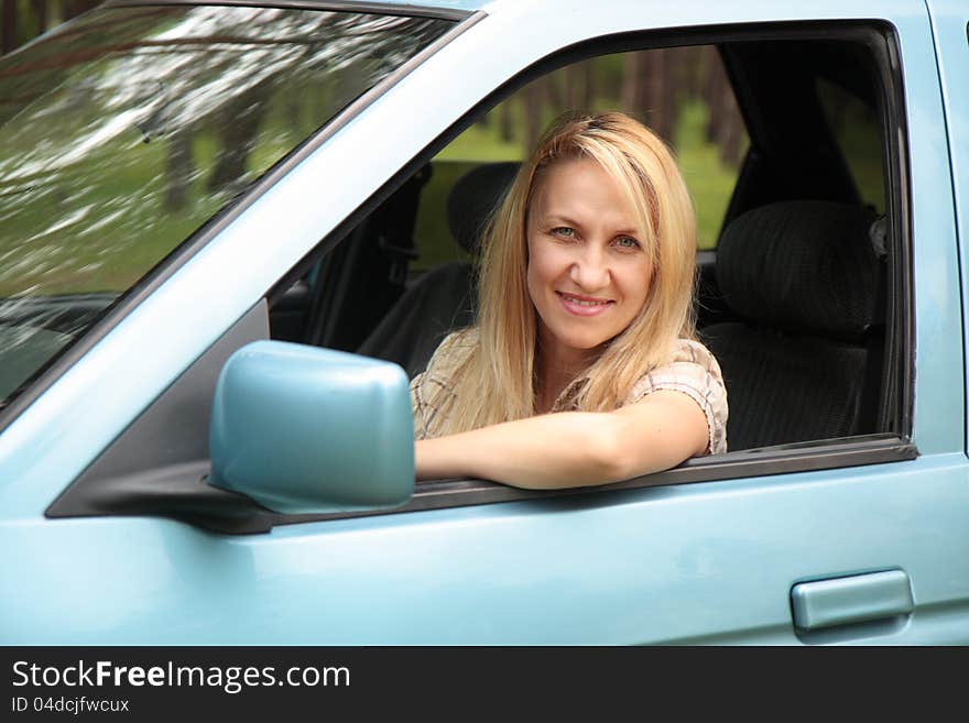 Smiling young  woman in the car